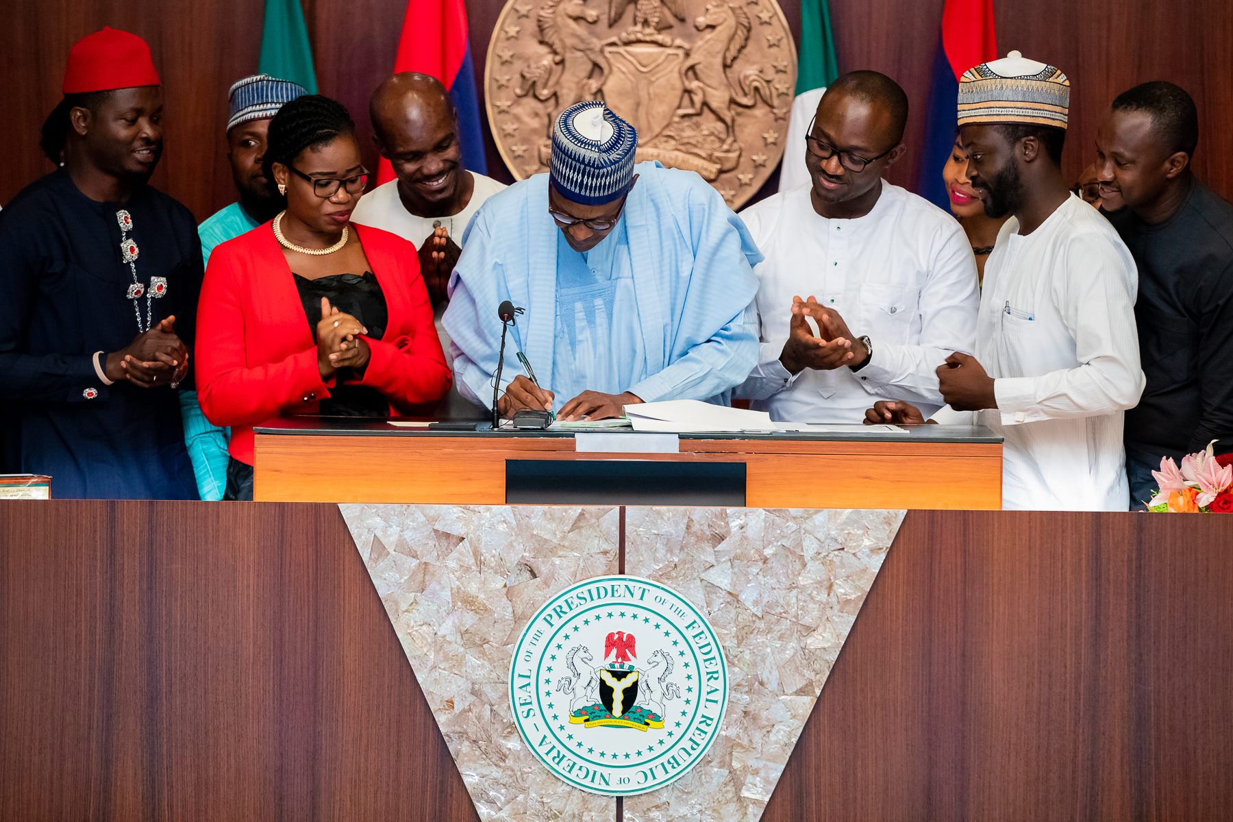 President Buhari signing into law on Thursday at the Presidential Villa, Abuja, the Not Too Young To Run bill. With him are members of the Not Too Young To Run Movement led by its coordinator, Samson Itodo(Third from right)